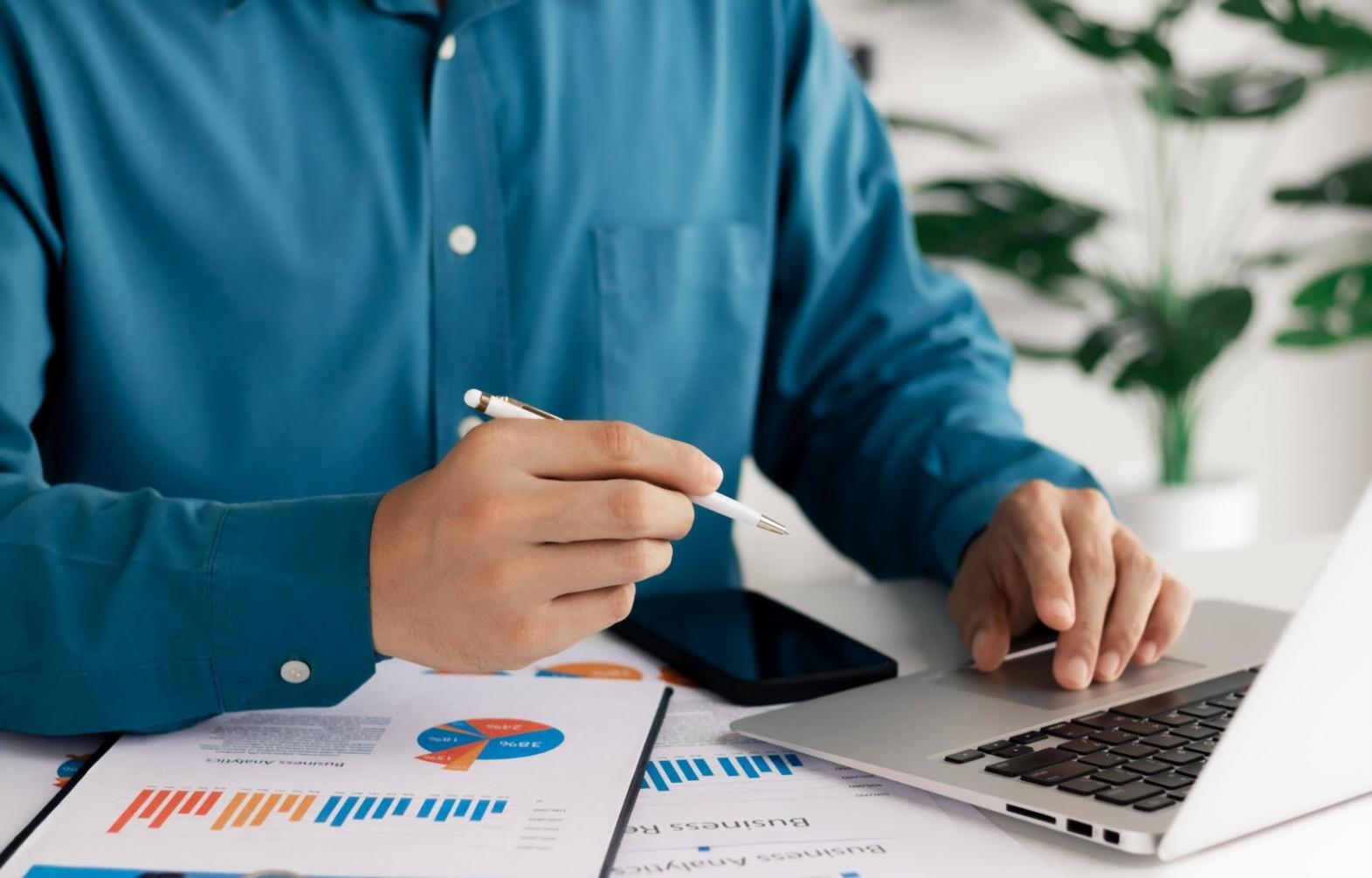 Person reviewing financial statements and budget tracking tools
